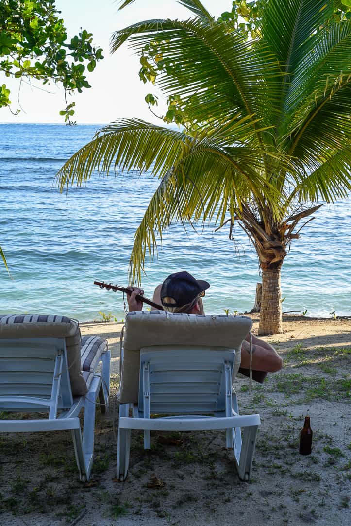 maqai eco surf resort eric playing guitar in lounge chair beachfront