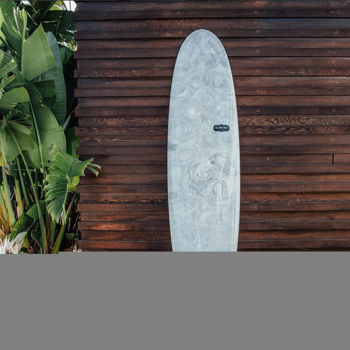 surfboard almond surfboards grey swirl design against darkwood wall 