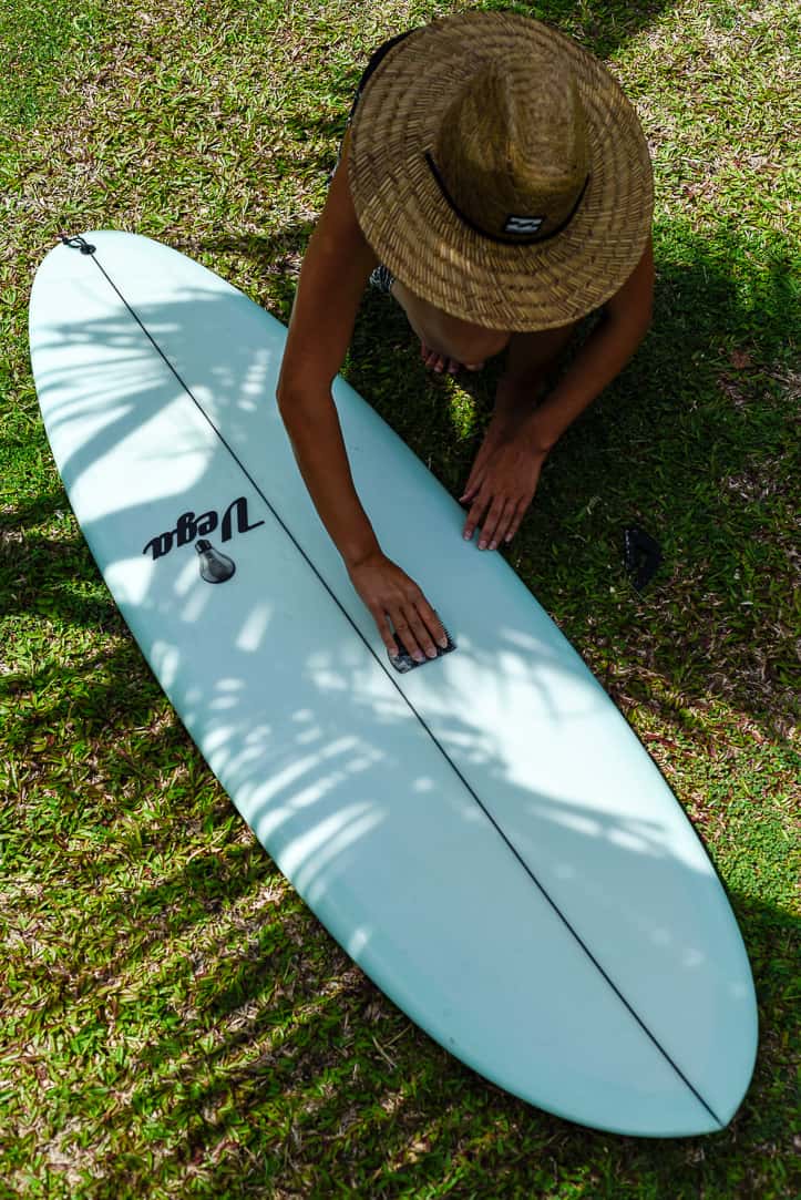 surf and yoga retreat sri lanka girl waxing surfboard