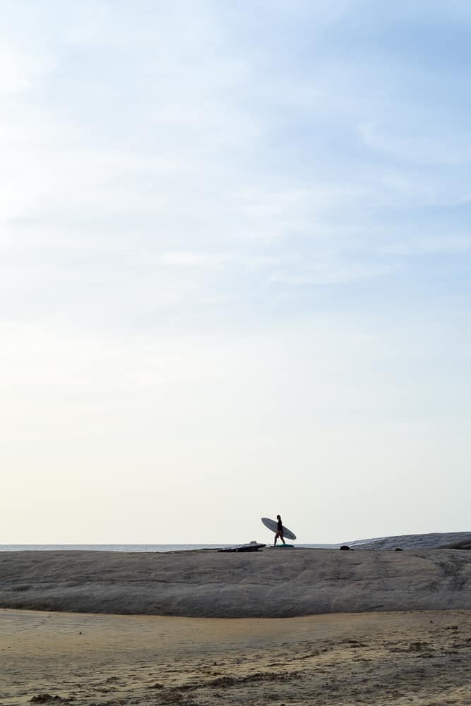 surfer walking on rocky horizon sri lanka surf