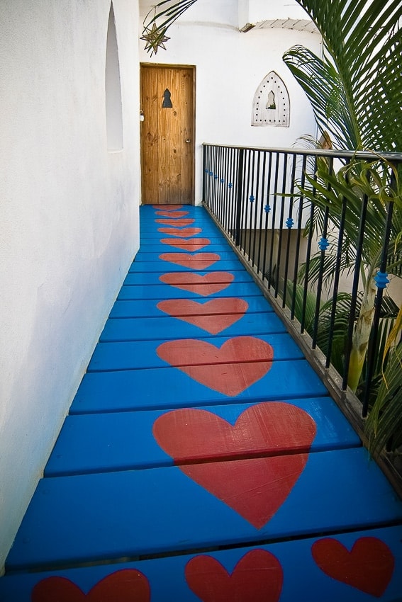 walk way painted blue with red hearts leading to hotel room sayulita mexico