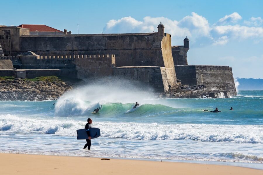 surfers at carcavelos beach portugal