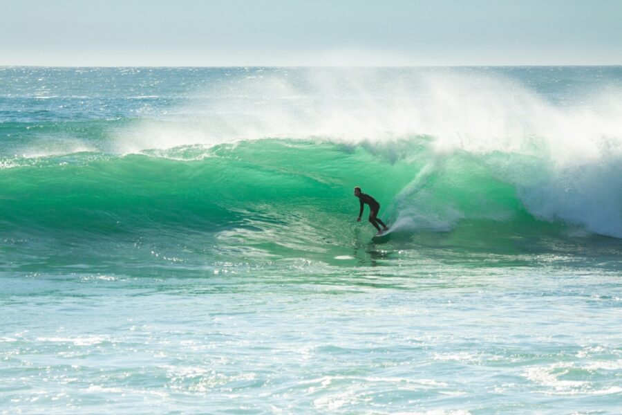 surfer riding wave at arrifana portugal