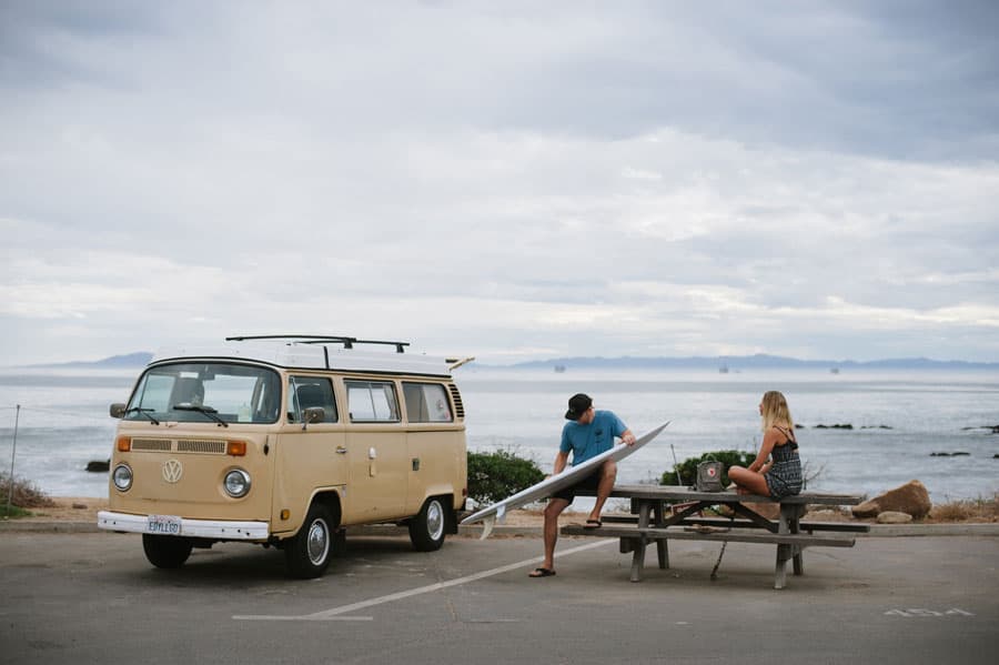 vintage vw bus surfer waxing surfboard picnic table carpinteria