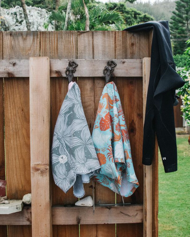 boardshorts by Vissla surf brand hanging on wood fence