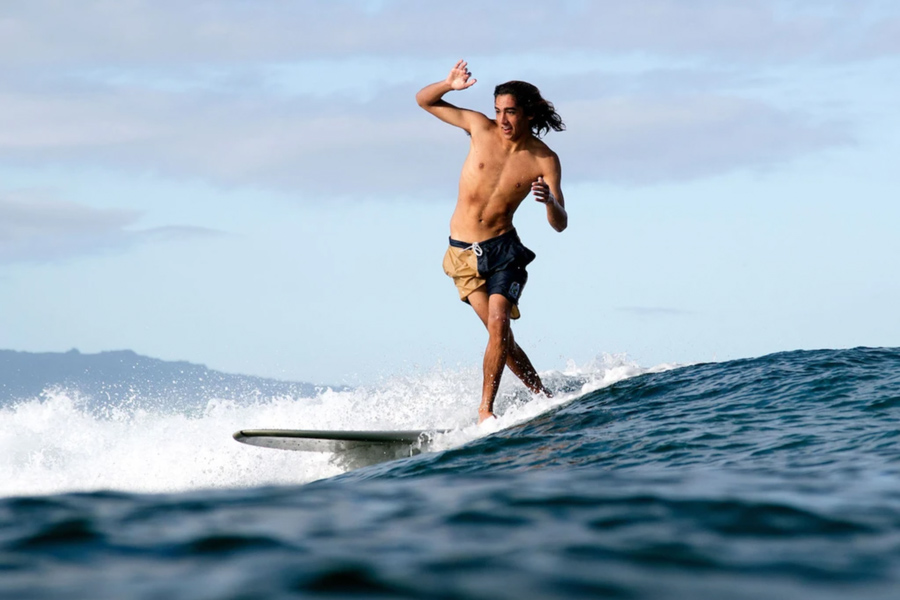 Surfista praticando longboard com boardshorts Katin