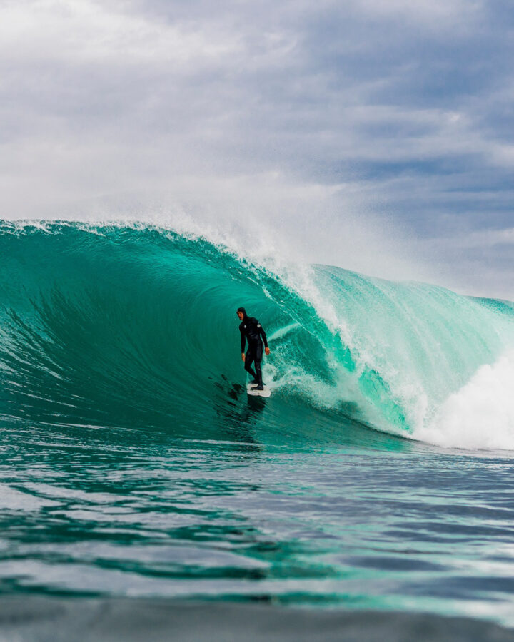 surfer in barrel wearing wetsuit by rip curl surf company