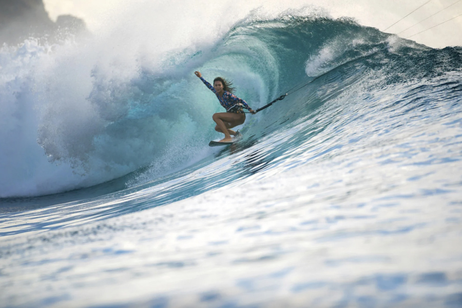 mulher surfando onda grande - usando roupa de surfe da patagônia