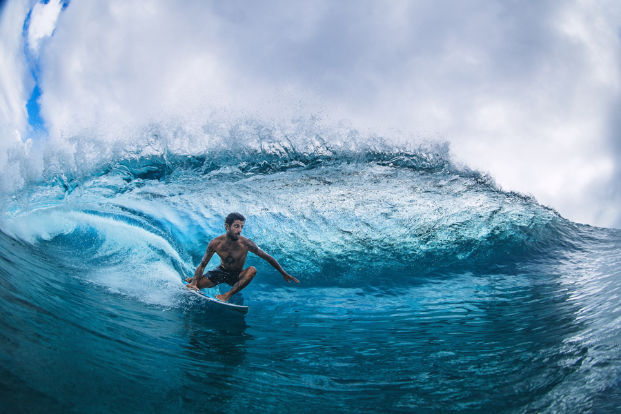 o surfista profissional filipe toledo surfando o barril usando boardshorts da marca hurley surf