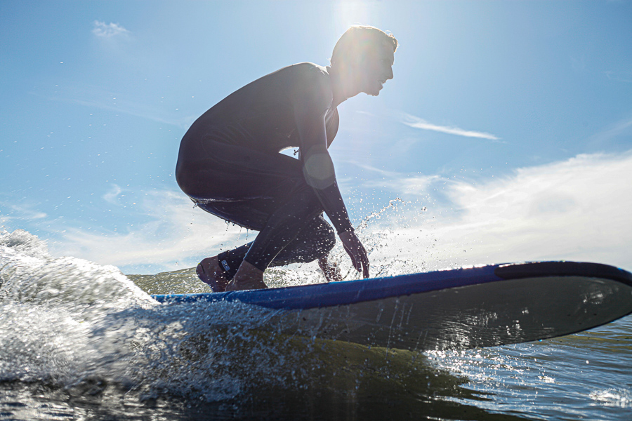 man learning how to surf on beginner surfboard