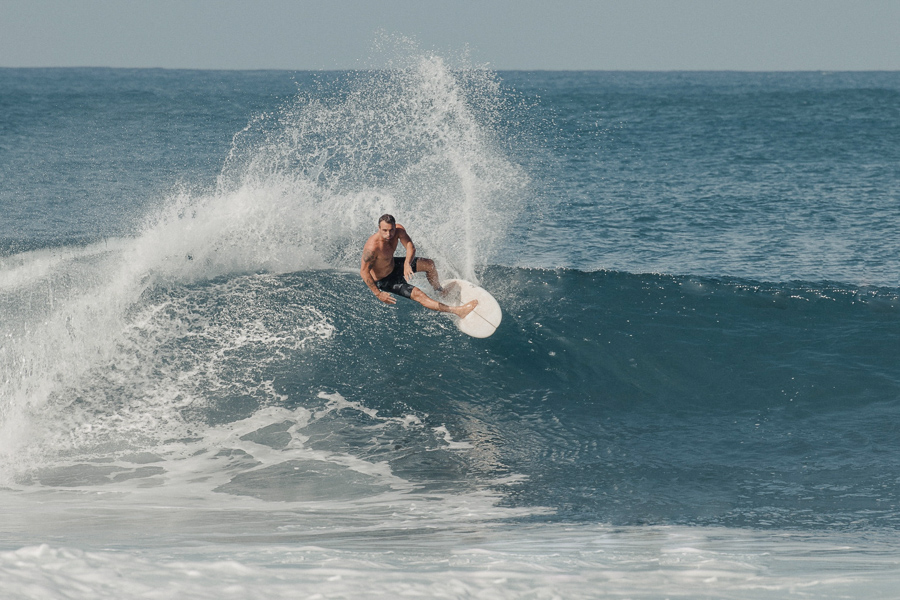 Homem surfando onda - Como escolher uma prancha de surfe depende do seu nível de surfe