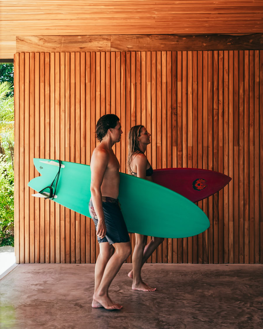 guy and girl surfers walking with surfboards